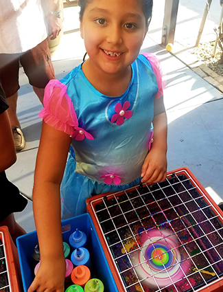 Girl doing spin art by Joe's Party Animals at a party.