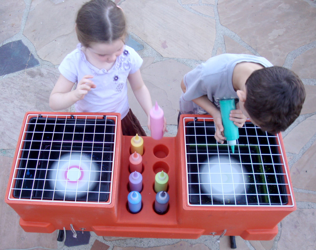 Two Kids making spin art at a spin art party in Los Angeles California